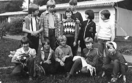 Gruppenfoto Kinder mit Erzieherin vor Bungalow