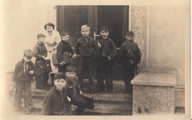 Gruppe Jungs mit Schulmappen und Ursula Fricke vor Haus 1