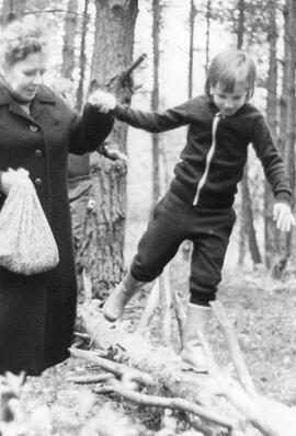 Frau mit Kind beim Balancieren im Wald
